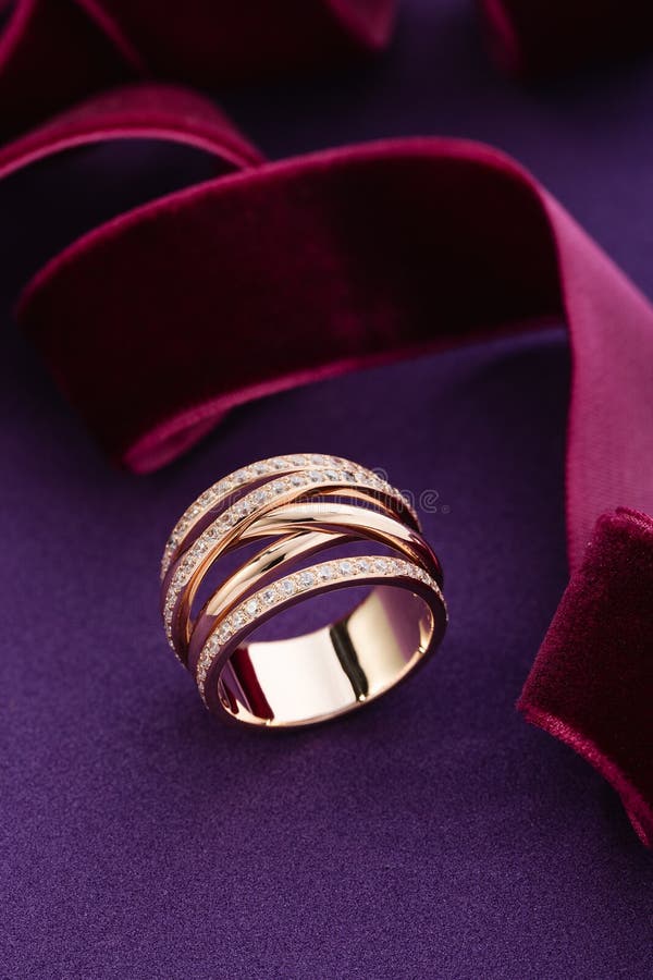 Pink gold fashion ring with diamonds on purple background stock photos Pink gold fashion ring with diamonds on purple background stock photos