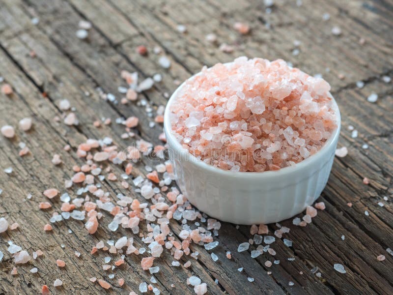 Pink Himalayan salt in white salt shaker on wooden background. Healthy spice closeup stock image Pink Himalayan salt in white salt shaker on wooden background. Healthy spice closeup stock image