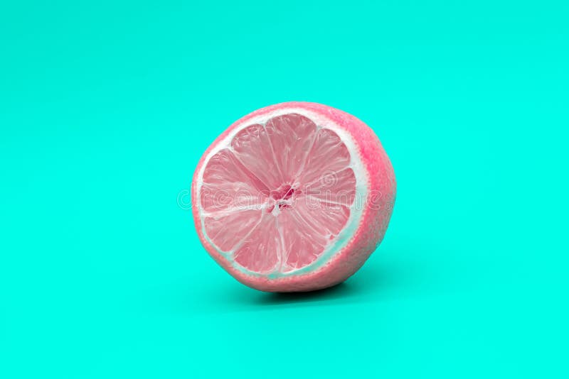 Pink lemon on a green background, the concept of changing yourself and your nature