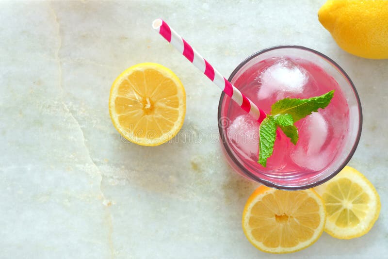 Pink lemonade with mint and lemons, overhead view on marble