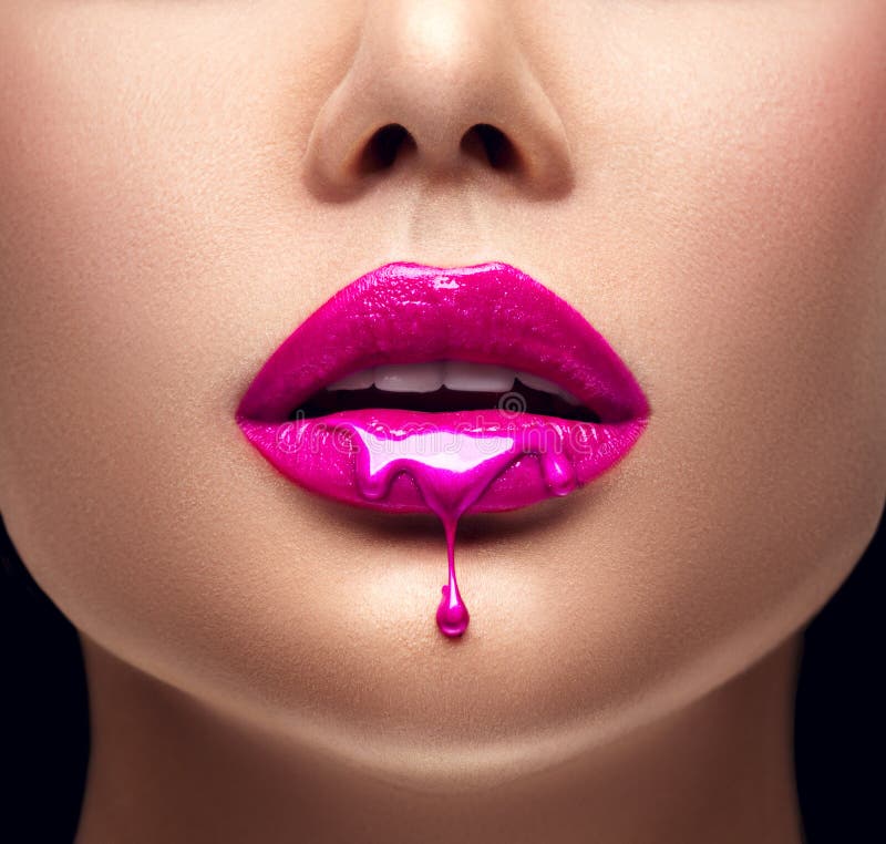 Pink lipstick dripping. Lipgloss dripping from lips, Purple liquid drops on beautiful model girl`s mouth, creative makeup