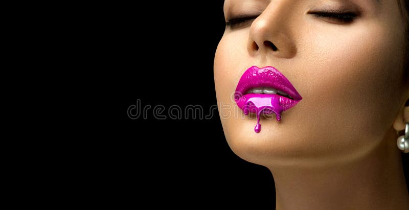 Pink Lipstick dripping. Paint drops on red lips, lipgloss dripping from sexy lips, Purple liquid drops on beautiful model girl`s m