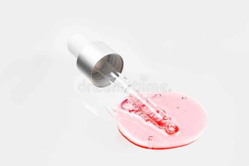 Pink liquid of gel or oil essense serum with pipettes on white isolated