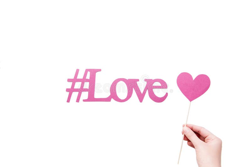 Pink love hashtag with heart sign in hand isolated on white