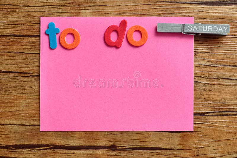 A pink note with the words to do and a peg attached with the word saturday on it