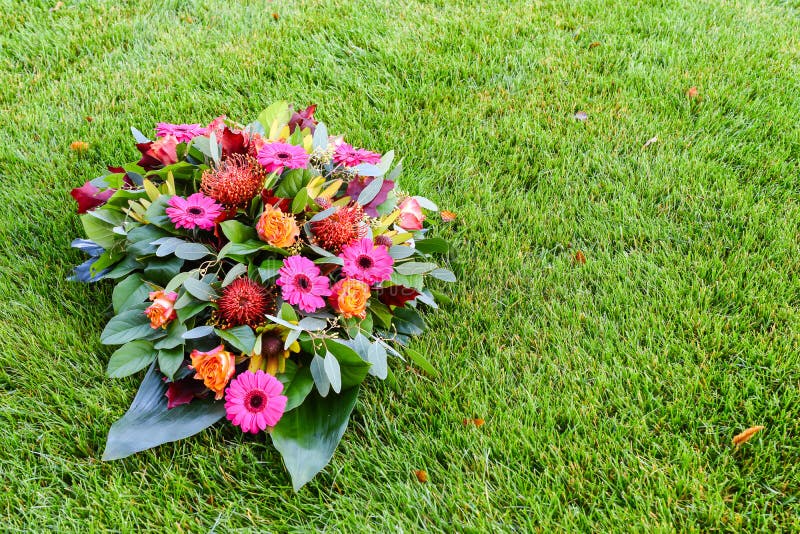 Pink and orange colored flower arrangement on lawn. All Saints day flower arrangements, flowers for grave and funeral. stock image Pink and orange colored flower arrangement on lawn. All Saints day flower arrangements, flowers for grave and funeral. stock image