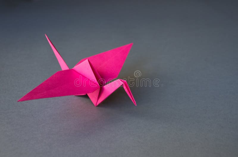 Pink Paper Crane Origami Isolated on a Grey Background Stock Photo