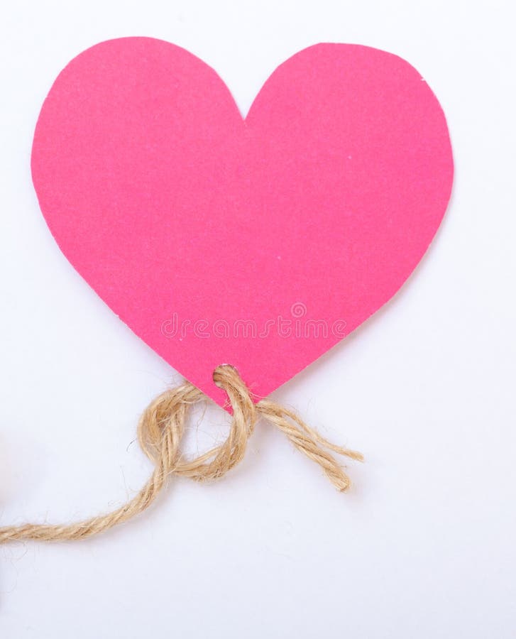 Pink paper heart shape with old string as symbol of love. Valentine's day or card. White background. Studio shot. Pink paper heart shape with old string as symbol of love. Valentine's day or card. White background. Studio shot.