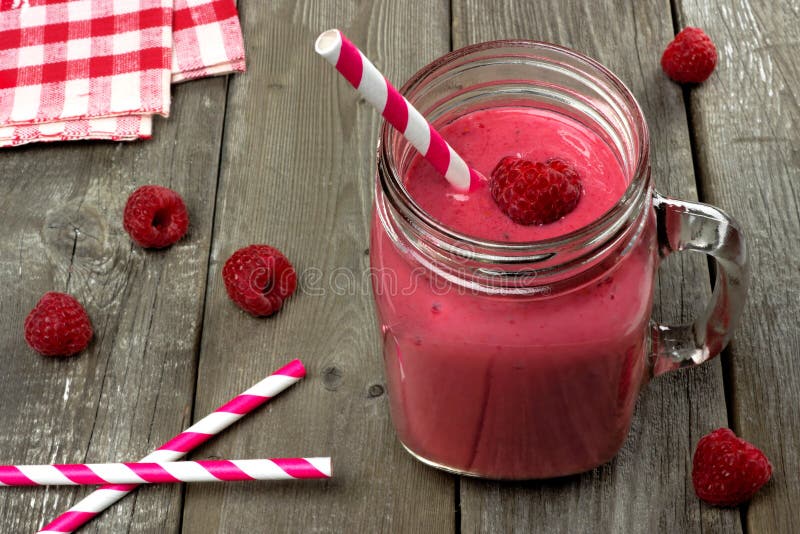 Pink raspberry smoothie against rustic wood