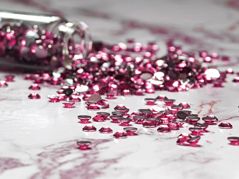 Pink Rhinestones Poured from a Glass Bottle on a Marble Table Stock ...