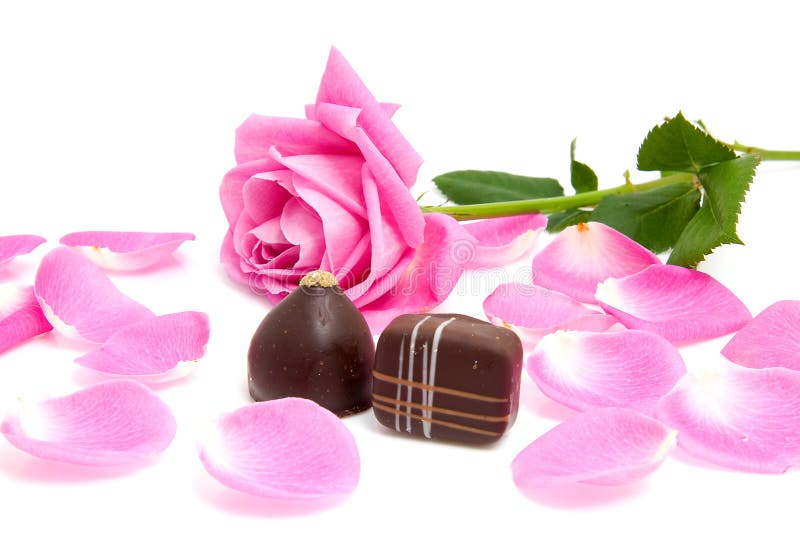 Ružové ruže a listov s čokoládové bonbóny pre Valentines day nad bielom pozadí.