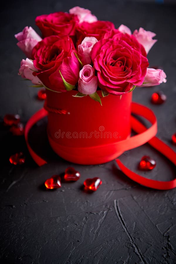 Pink roses bouquet packed in red box and placed on black stone background royalty free stock image Pink roses bouquet packed in red box and placed on black stone background royalty free stock image