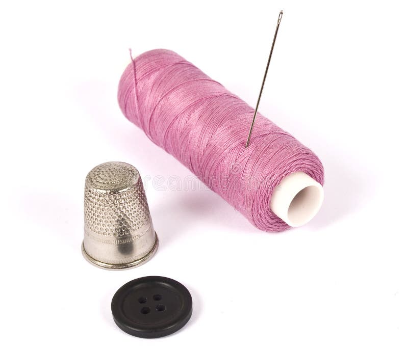 Premium Photo  A spool of pink thread a needle and a thimble on a pink  background