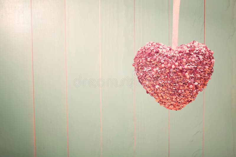 Pink shiny heart on vintage green wood background stock photo