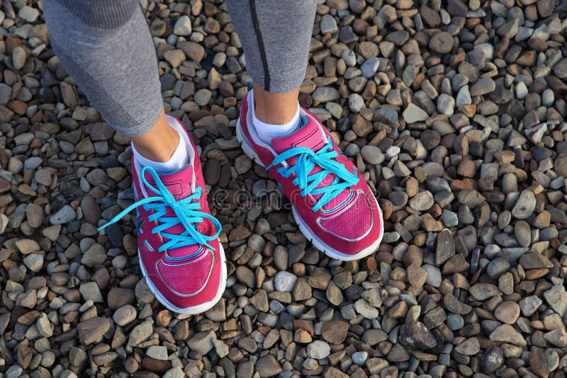 Pink sports shoes on gravel. - Stock Image - Everypixel