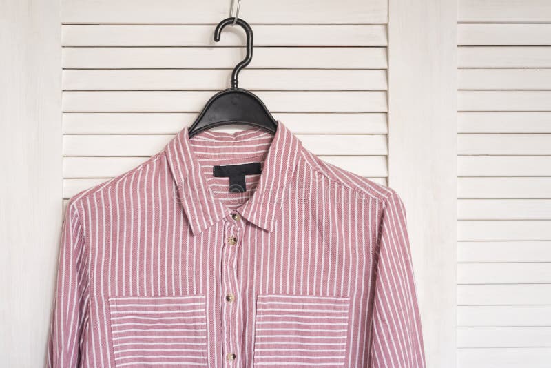 Pink Stried Shirt Hanging On A Hanger. White Wooden Screen On Th Stock ...