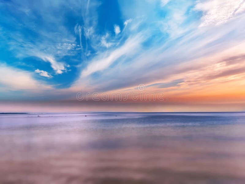 Pink sunset at sea blue sky fluffy clouds and ocean water nature landscape  background