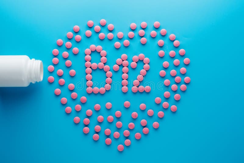 Pink Tablets In The Form Of Vitamins B12 In The Heart On A Blue