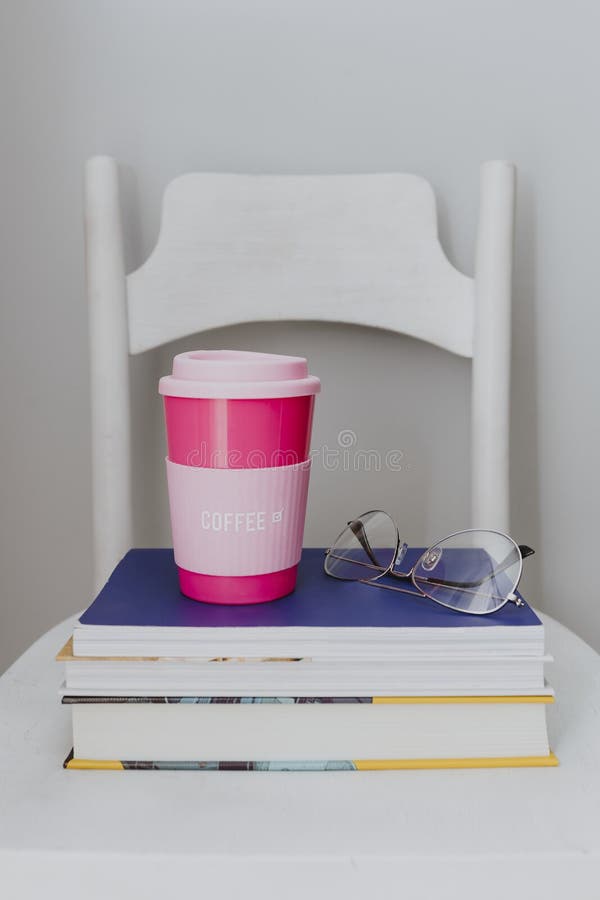 Pink travel mug on a stack of textbooks royalty free stock images