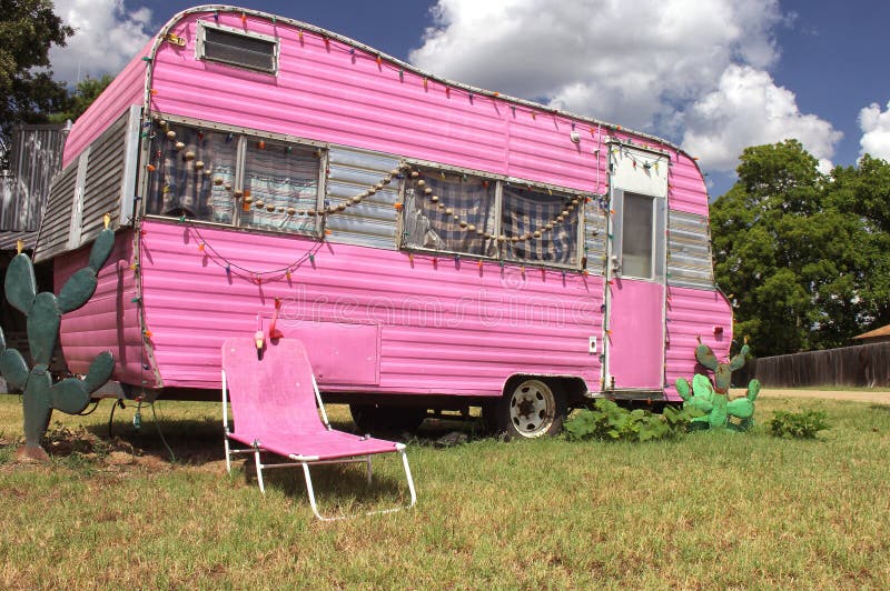 Pink Travel Trailer with Chair and cactus plus blue sky and clouds royalty free stock photo