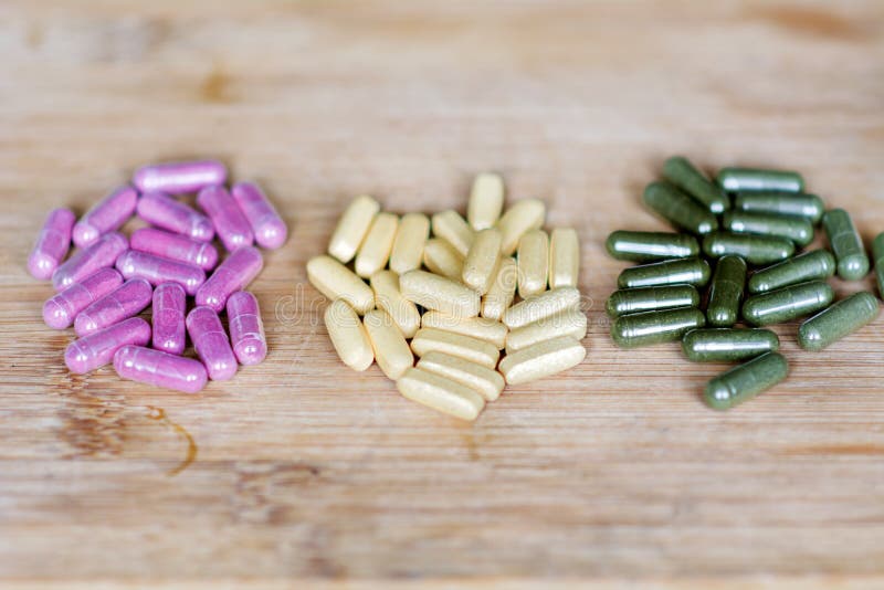 Pink,yellow and green pills on a wooden background royalty free stock photo Pink,yellow and green pills on a wooden background royalty free stock photo