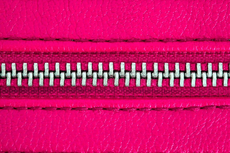 Pink zipper tightly closed binding together two layers of fabric textile and leather under high magnification close detail stock image