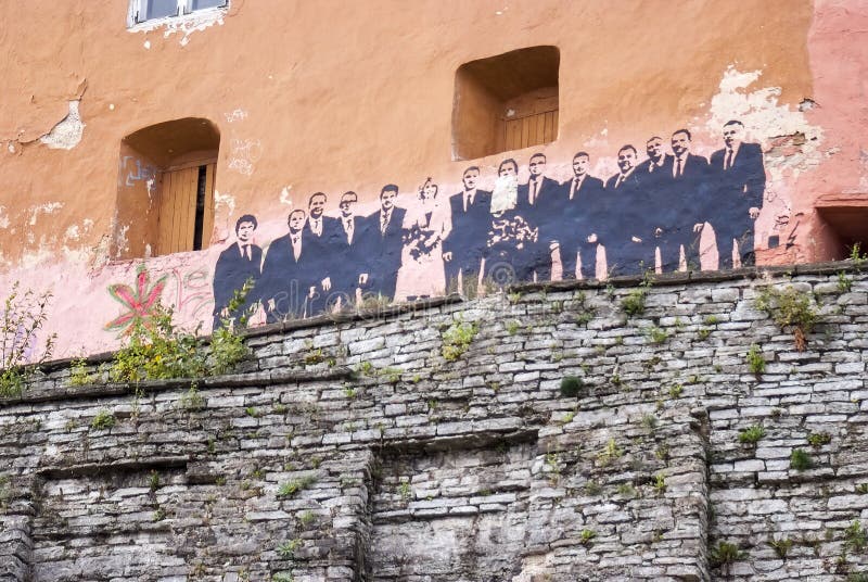 Interesting, non trivial photo of a huge black graffiti in the centre of Old town of Tallinn in Estonia. Picture shows, probably, some world leaders or politicians in full growth (there's no exact information about it). Some people in official suits stand in a group (raw of people). It looks like they stand at the top of city's ancient fortification (tower's wall). For different purposes (saving historical architecture, graffiti, politics, world cooperation, travelling, etc.). Interesting, non trivial photo of a huge black graffiti in the centre of Old town of Tallinn in Estonia. Picture shows, probably, some world leaders or politicians in full growth (there's no exact information about it). Some people in official suits stand in a group (raw of people). It looks like they stand at the top of city's ancient fortification (tower's wall). For different purposes (saving historical architecture, graffiti, politics, world cooperation, travelling, etc.).