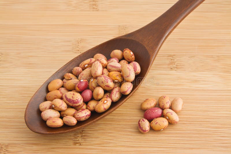 Pinto beans on a wooden spoon