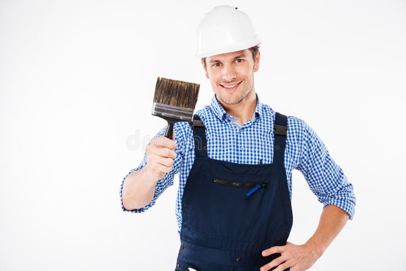 Pintor de sexo masculino sonriente que sostiene la brocha fotografía de archivo Pintor de sexo masculino sonriente que sostiene la brocha fotografía de archivo
