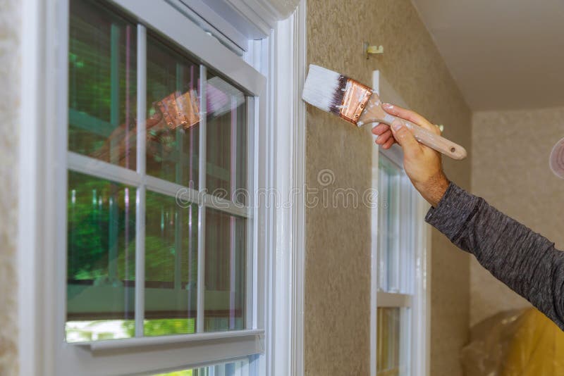 Pintor que pinta el ajuste de la ventana o moldear de una casa fotografía de archivo libre de regalías Pintor que pinta el ajuste de la ventana o moldear de una casa fotografía de archivo libre de regalías