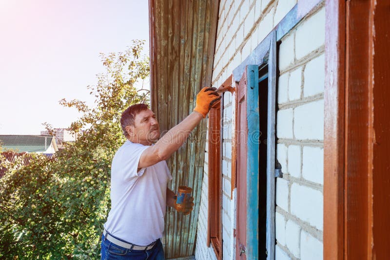 Pintor que pinta las ventanas del trabajo de renovación exterior de la casa fotografía de archivo libre de regalías Pintor que pinta las ventanas del trabajo de renovación exterior de la casa fotografía de archivo libre de regalías