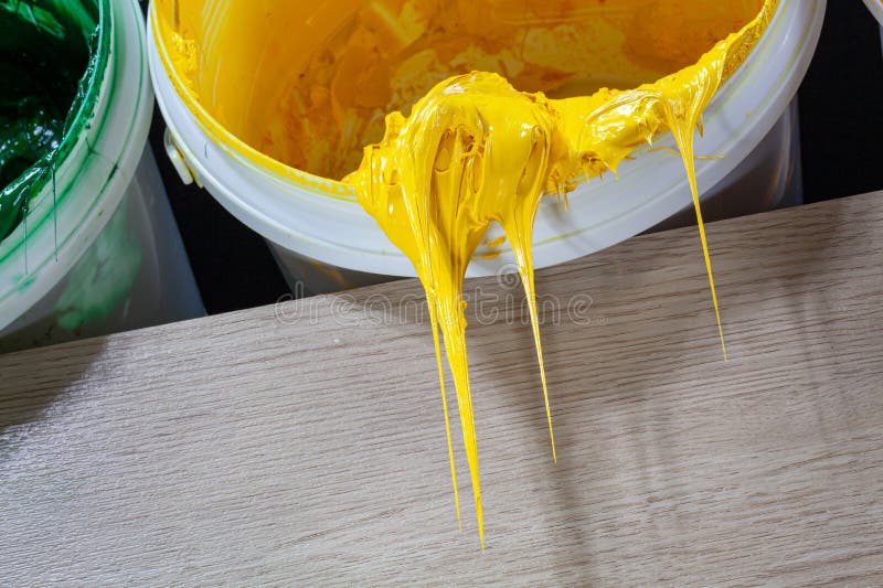 Yellow paint dripping from white barrel..plastisol ink is used for printing on fabrics because it is durable,. easily cured and can be stretched without cracking or becoming distorted. Yellow paint dripping from white barrel..plastisol ink is used for printing on fabrics because it is durable,. easily cured and can be stretched without cracking or becoming distorted