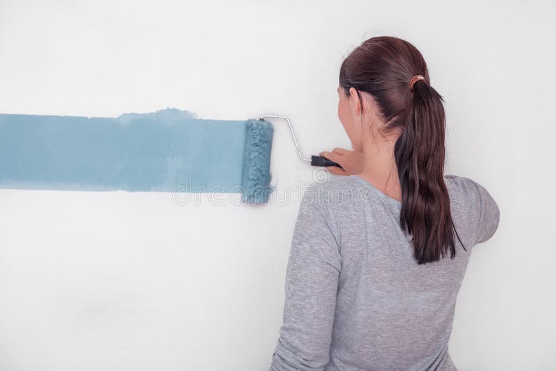 Female decorating with color a wall. Female decorating with color a wall