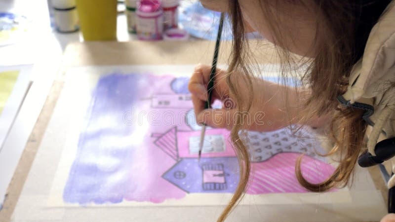 Pintura de dos mujeres adultas con las pinturas acrílicas coloreadas en un cierre de la escuela de arte para arriba