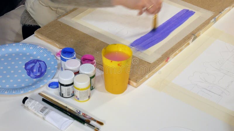 Pintura de las mujeres adultas con las pinturas acrílicas coloreadas en un cierre de la escuela de arte para arriba