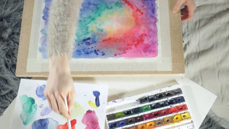 Pintura de las mujeres adultas con las pinturas coloreadas de la acuarela en un cierre de la escuela de arte para arriba