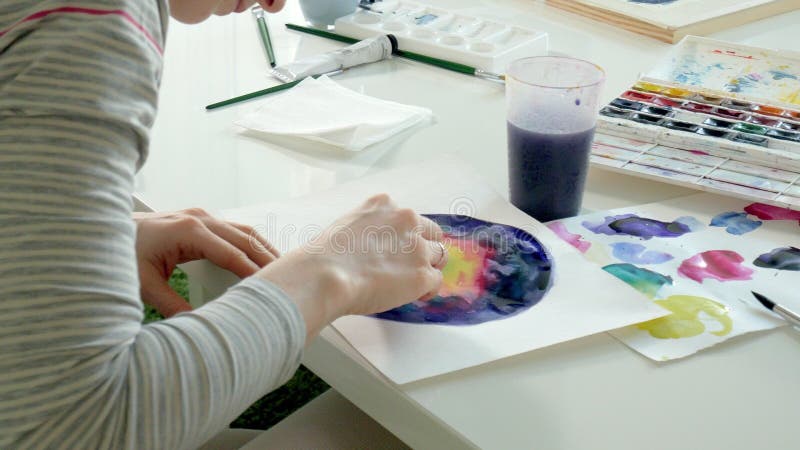 Pintura de las mujeres adultas con las pinturas coloreadas de la acuarela en un estudio casero