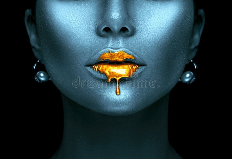 A pintura do ouro goteja dos bordos 'sexy', gotas líquidas douradas na boca modelo bonita do ` s da menina, obscuridade abstrata imagem de stock