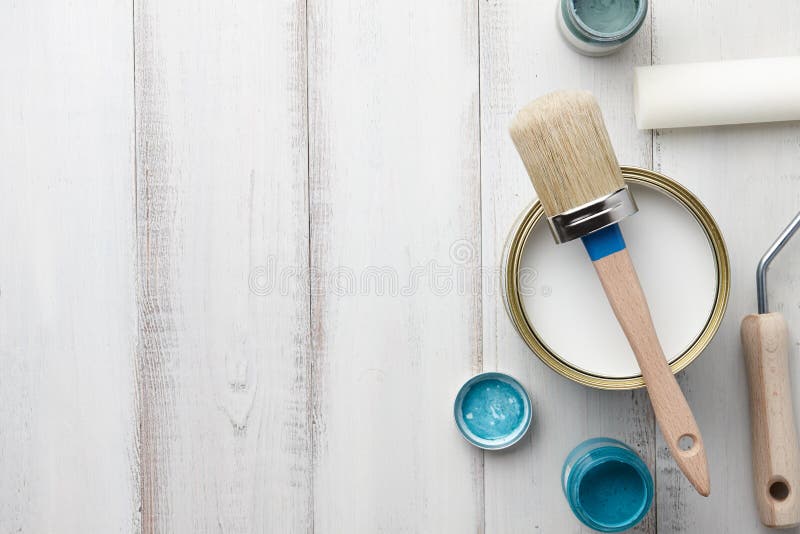 Paint brush, sponge roller, paints, waxes and other painting or decorating supplies on white wooden planks, top view. Paint brush, sponge roller, paints, waxes and other painting or decorating supplies on white wooden planks, top view