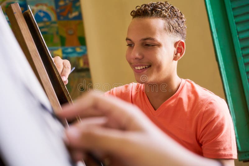 Pintura nova do homem novo de Drawing In College do artista na escola imagens de stock royalty free Pintura nova do homem novo de Drawing In College do artista na escola imagens de stock royalty free