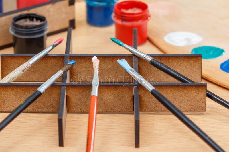 Pinturas y cepillos coloridos en un soporte de madera listo para pintar fotografía de archivo libre de regalías Pinturas y cepillos coloridos en un soporte de madera listo para pintar fotografía de archivo libre de regalías