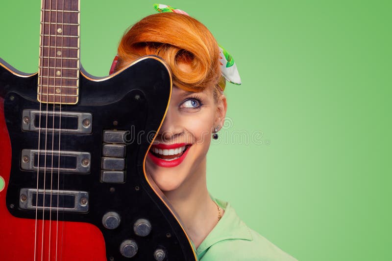 Pinup girl with electric acoustic rock guitar smiling