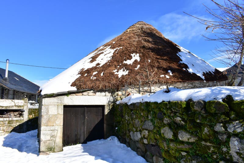 Piornedo Ancares, Galicia, Spanien Forntida snöig pallozahus som göras med stenen och sugrör Bergby, vinter och snö arkivfoton Piornedo Ancares, Galicia, Spanien Forntida snöig pallozahus som göras med stenen och sugrör Bergby, vinter och snö arkivfoton