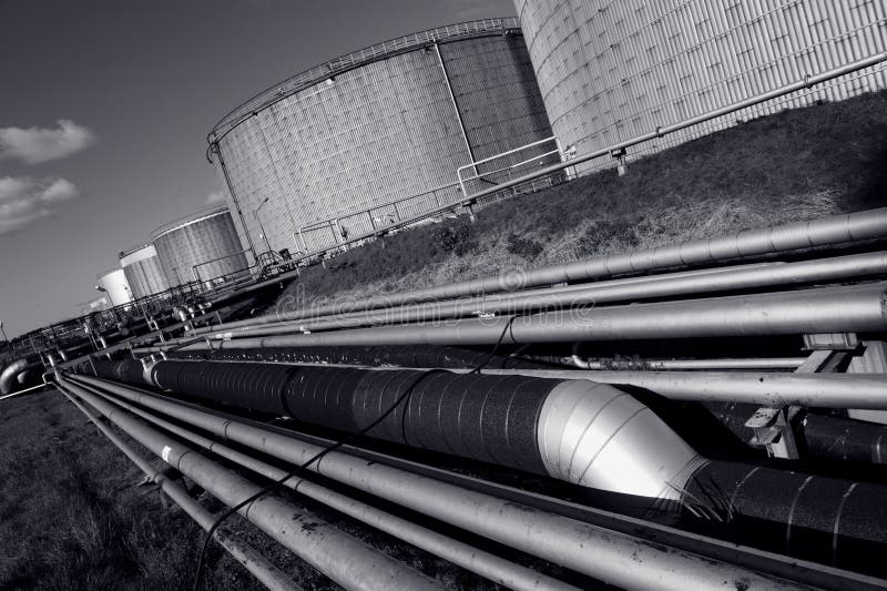 Large pipeline construction with six fuel-storage tanks, as seen inside oil industry. dark duplex toning idea. Large pipeline construction with six fuel-storage tanks, as seen inside oil industry. dark duplex toning idea.