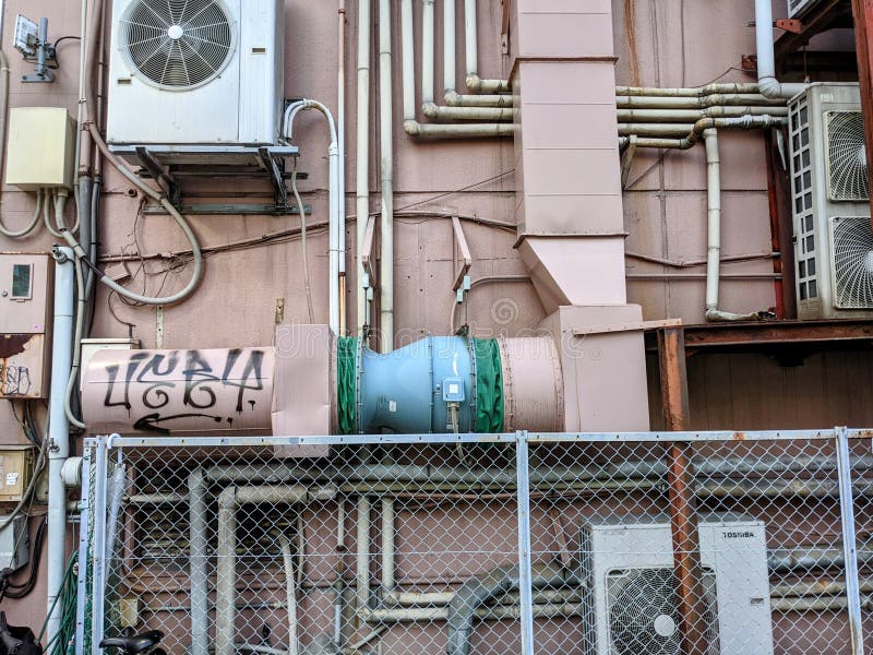 Pipes and Air Conditioning Unit on the Exterior of a Building Stock