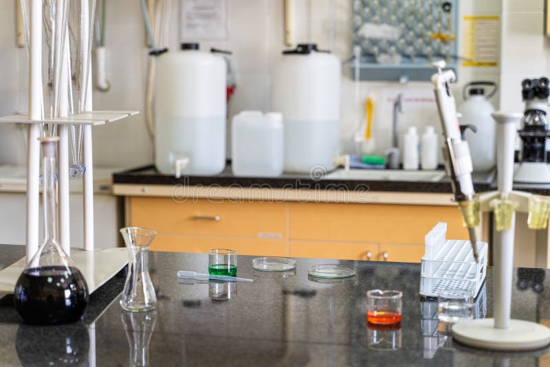 Pipet en kleurrijke chemische vloeibare oplossingen in flessen op laboratorium worktop royalty-vrije stock afbeelding Pipet en kleurrijke chemische vloeibare oplossingen in flessen op laboratorium worktop royalty-vrije stock afbeelding