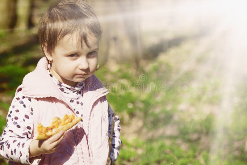 Pique-nique Belle petite fille appréciant une pizza délicieuse dans le natu images stock Pique-nique Belle petite fille appréciant une pizza délicieuse dans le natu images stock