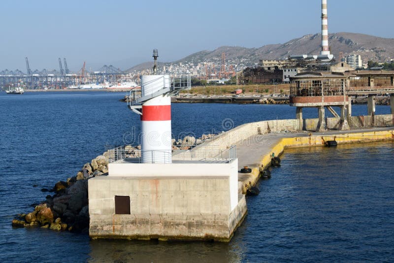 Piraeus fyr med ett rött band som navigerar skepp som skriver in porten av Aten arkivbild Piraeus fyr med ett rött band som navigerar skepp som skriver in porten av Aten arkivbild