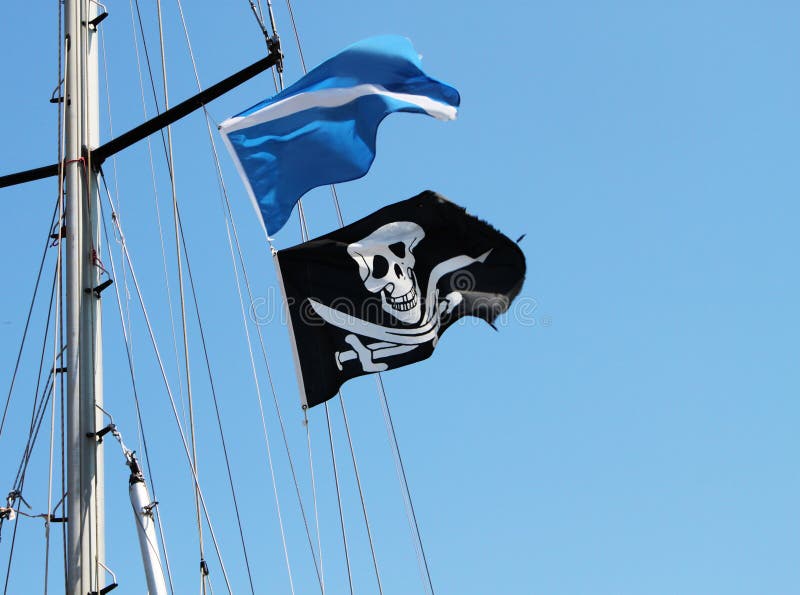 Black and white pirate skull and swords flag waving on mast. Black and white pirate skull and swords flag waving on mast