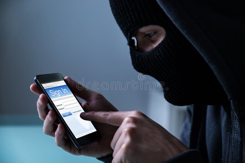 Close-up Of Hacker Using Smart Phone To Steal Data In Office. Close-up Of Hacker Using Smart Phone To Steal Data In Office